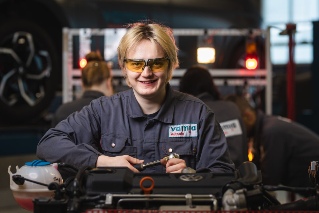 Autopuolen opiskelija räikkä kädessä.
